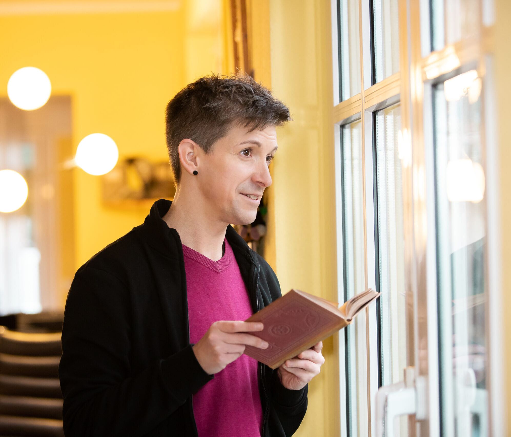 Mio Lindner Lerntherapeut liest Buch am Fenster