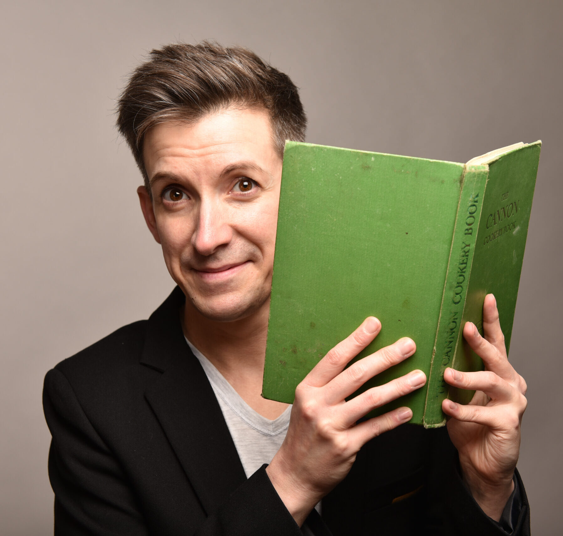 Mio Lindner Lerntherapeut hält grünes Buch vor Gesicht